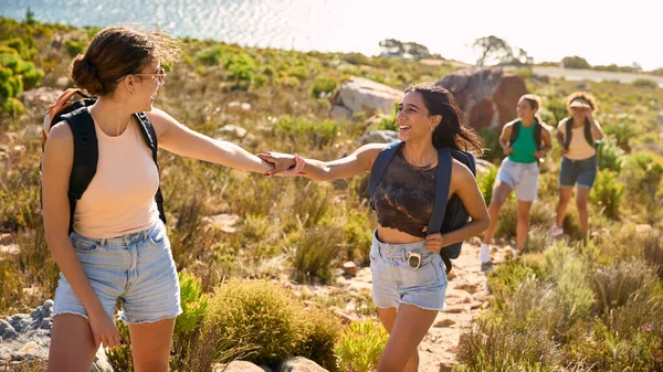Sırt Çantalı Bir Grup Kız Arkadaş Sahil Yolunda Yürüyüş Yaparken — Stok fotoğraf