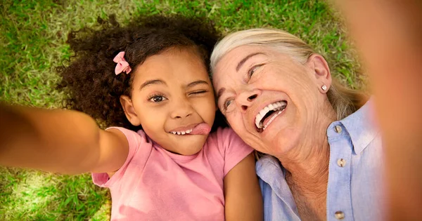 Pov Nad Głową Ujęcie Babci Wnuczki Leżących Trawie Biorąc Selfie — Zdjęcie stockowe