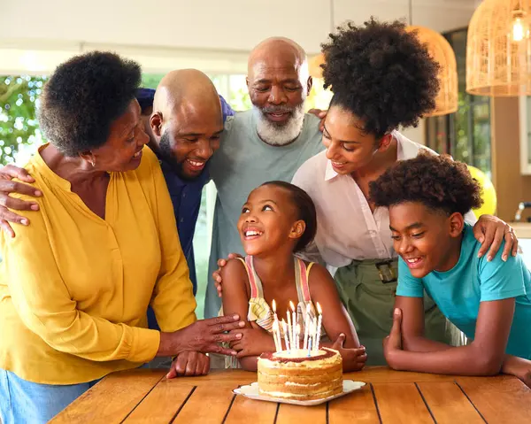 家でケーキとろうそくで孫娘の誕生日を祝う多世代家族 — ストック写真