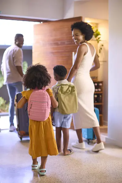 Family By Door With Suitcases Leaving Home For Holiday Or Vacation
