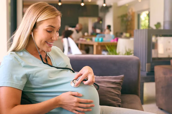 Беременная Женщина Дома Слушает Детское Сердцебиение Стетоскопом — стоковое фото