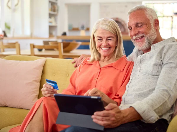 Gepensioneerd Senior Paar Thuis Met Digitale Tablet Maken Aankoop Reserveren — Stockfoto