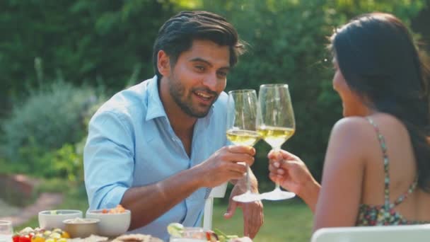 情侣们在自家花园享用户外大餐 举杯庆祝白葡萄酒 动作缓慢 — 图库视频影像