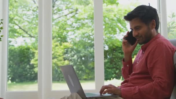 Evden Çalışan Bir Adam Koltuğa Yaslanmış Dizüstü Bilgisayarla Ağır Çekimde — Stok video