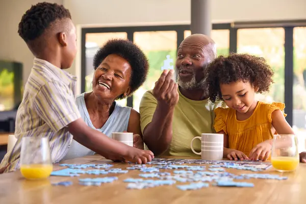 Girato Famiglia Con Nonni Nipoti Che Fanno Puzzle Sul Tavolo — Foto Stock