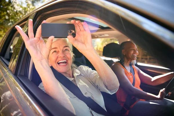 Pasażer Biorąc Selfie Telefon Komórkowy Jako Dwie Starsze Przyjaciółki Cieszyć — Zdjęcie stockowe