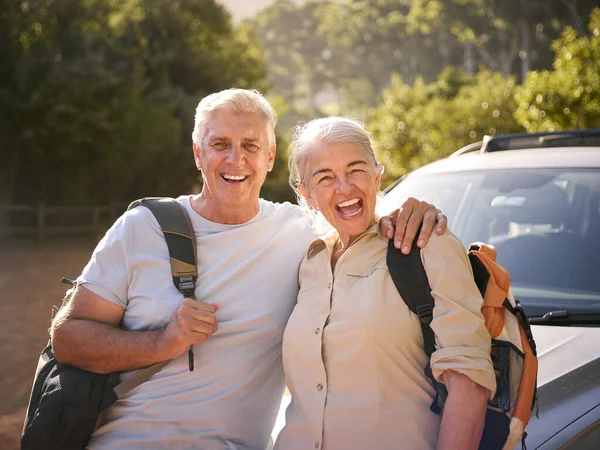 Portrait Of Senior Couple Going For Hike In Countryside Standing By Car Together