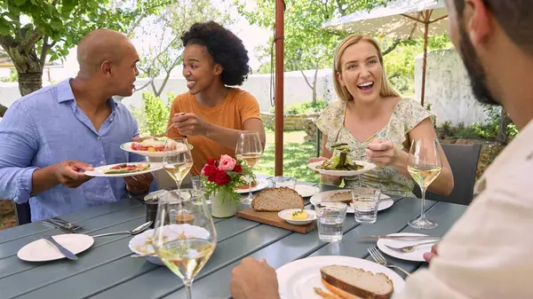 Freundesgruppe Genießt Essen Und Wein Freien Bei Einem Besuch Vineyard Stockbild