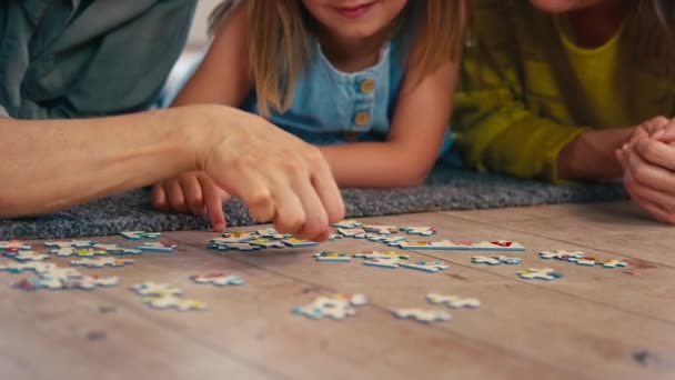성숙한 엄마와 퍼즐을 퍼즐을 바닥에 동일한 가족의 슬로우 모션에서 — 비디오
