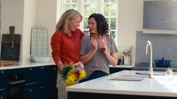 女人在家里站在厨房里的时候 竟然拿着鲜花给同性伴侣惊喜 动作缓慢 — 图库视频影像