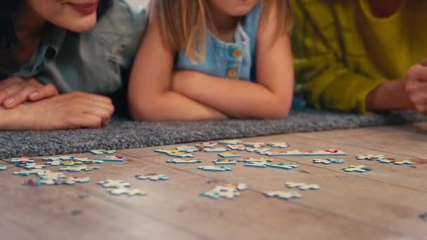 성숙한 엄마와 퍼즐을 퍼즐을 바닥에 동일한 가족의 슬로우 모션에서 — 비디오
