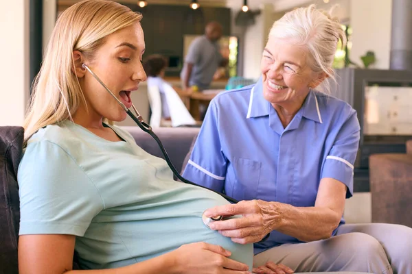 Senior Hebamme Mit Stethoskop Besucht Schwangere Hause Mit Familie Hintergrund — Stockfoto