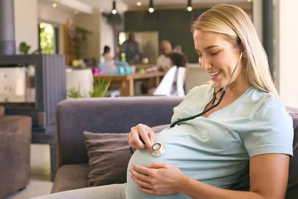 Gravid Kvinne Hjemme Lytte Til Baby Hjerterytme Med Stetoskop – stockfoto