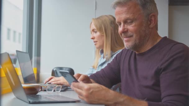 Kunden Coffeeshop Surfen Handy Und Arbeiten Fenster Laptops Aufgenommen Zeitlupe — Stockvideo