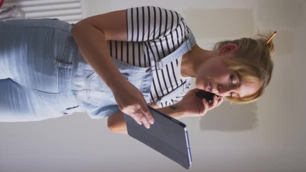 家の絵のテスターのペンキ色のストリップの部屋を改装する女性の垂直ビデオ ゆっくりとした動きで撮影 — ストック動画