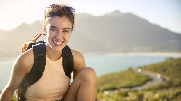 Portrait Of Woman With Backpack On Vacation Taking A Break On Hike By Sea