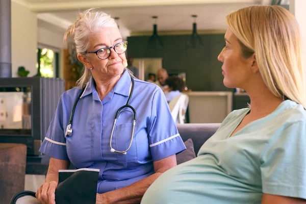 Senior Midwife Visiting Pregnant Woman Home Taking Blood Pressure Family — Stock Photo, Image