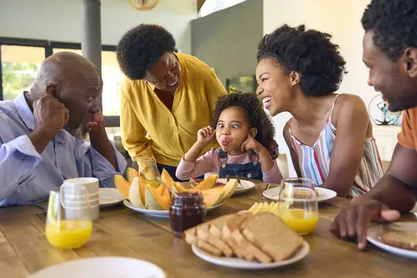 Family Shot Grandparents Parents Granddaughter Pulling Faces Breakfast Table Home — Stock Photo, Image
