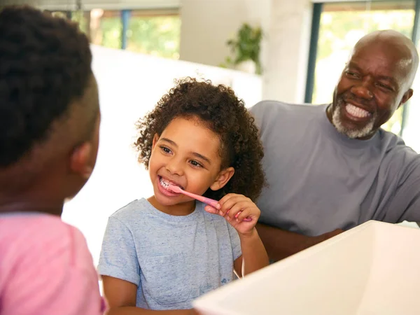 Dziadek Pomaga Wnukom Szczotkowanie Zębów Łazience Domu Przed Snem — Zdjęcie stockowe