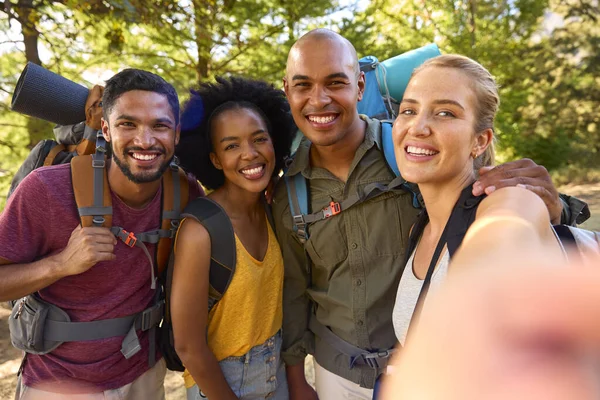 携带背包的朋友小组在手机上贴上自己的照片在乡间远足度假 — 图库照片