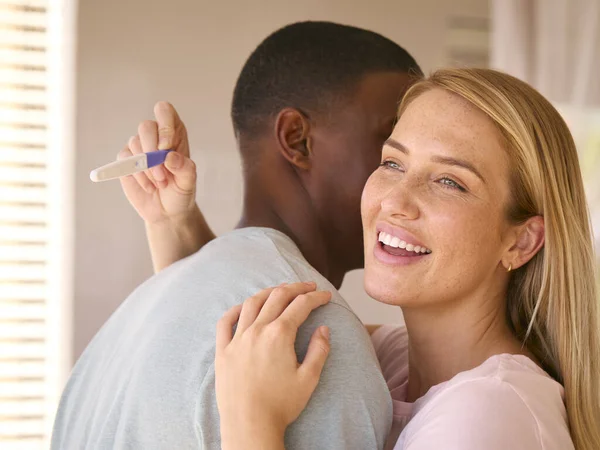 Knuffelen Multi Raciale Paar Slaapkamer Thuis Vieren Positieve Zwangerschap Test — Stockfoto
