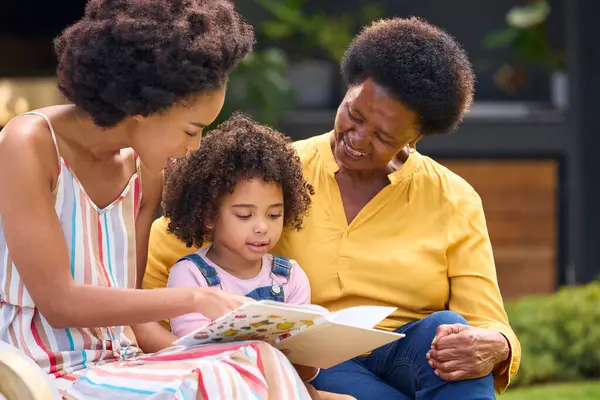 Glimlachende Multi Generatie Vrouwelijke Familie Leesboek Tuin Samen — Stockfoto