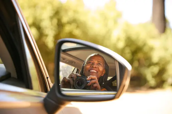 Uśmiechnięty Starszy Kierowca Kobieta Aparatem Odbity Lusterku Skrzydła Samochodu Korzystających — Zdjęcie stockowe