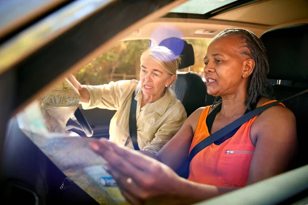 Dwie Zdezorientowane Starsze Przyjaciółki Jednodniowej Wycieczce Jadąc Samochodzie Czytanie Mapy — Zdjęcie stockowe