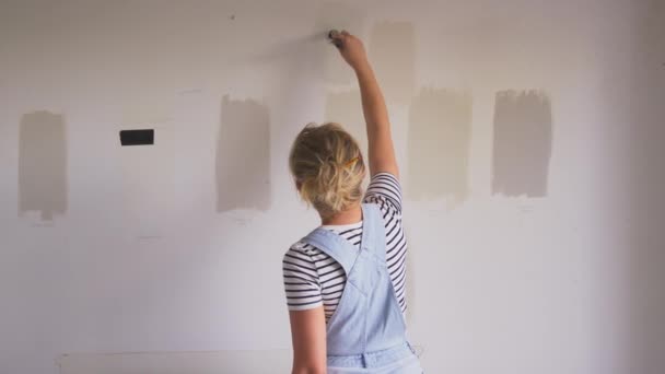 房屋油漆测试人员在墙上涂上彩带的妇女装修房间的后视镜 慢镜头拍摄 — 图库视频影像