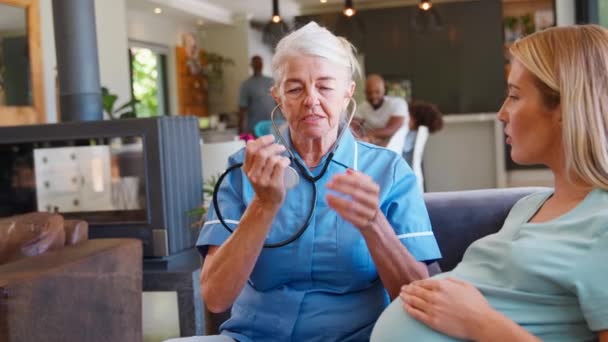 Senior Hebamme Mit Stethoskop Besucht Schwangere Hause Mit Familie Hintergrund — Stockvideo