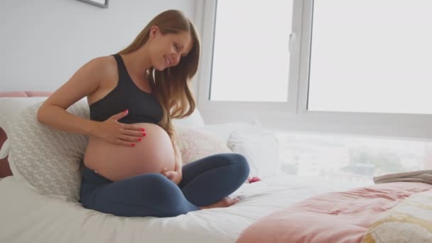 Hamile Bir Kadın Evde Rahat Rahat Oturup Spor Kıyafetlerini Giyiyor — Stok video