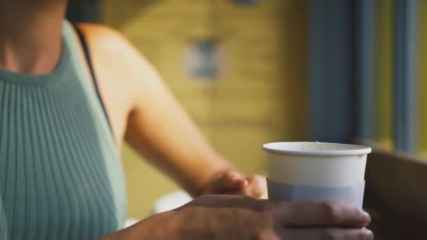 Kahve Dükkanının Vitrininde Oturan Kaşık Ile Sıcak Içeceği Karıştıran Kadının — Stok video