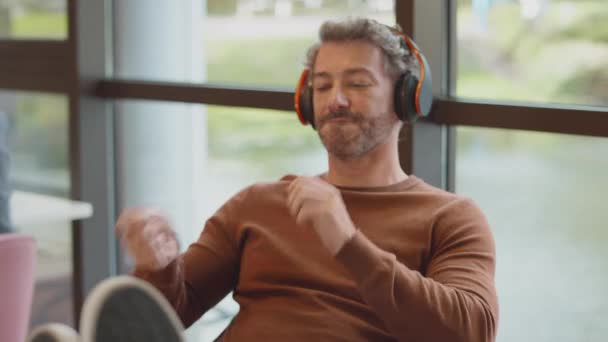 Mature Businessman Feet Desk Office Listens Music Wireless Headphones Air — Stock Video