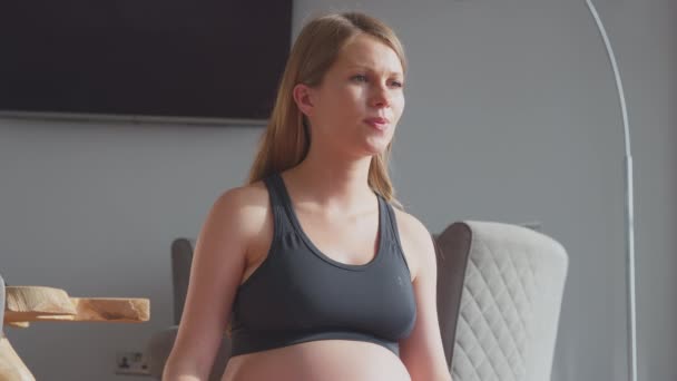 Hamile Kadın Spor Kıyafetleri Içinde Evde Oturmuş Nefes Alıyor Karnına — Stok video
