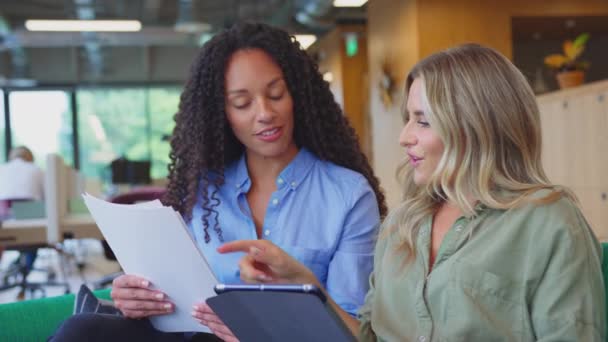 Two Businesswomen Digital Tablet Having Informal Meeting Breakout Seating Area — Stock Video