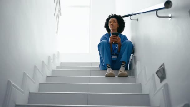 Stresli Kadın Hemşire Önlük Giyip Mesajları Kontrol Ediyor Hastane Merdivenlerinde — Stok video