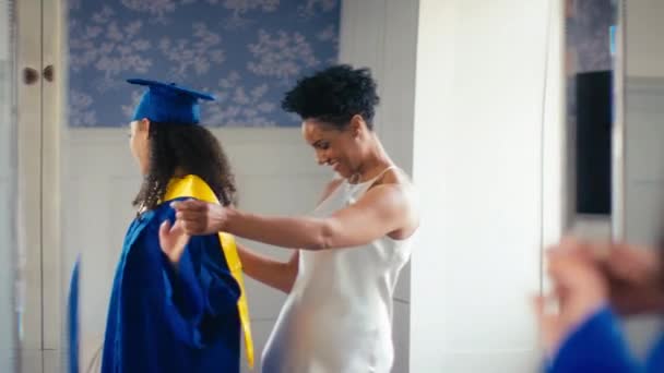 Orgullosa Madre Celebrando Con Hija Adolescente Con Batas Graduación Reflejadas — Vídeo de stock