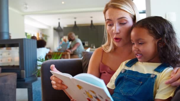 Мать Дочь Читают Книгу Дома Вместе Многодетной Семьей Заднем Плане — стоковое видео