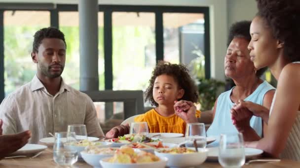 Mehrgenerationenfamilie Hält Sich Die Hände Und Betet Vor Dem Essen — Stockvideo
