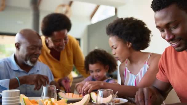 Familjen Äter Frukost Med Morföräldrar Och Barnbarn Äter Melon Hemma — Stockvideo