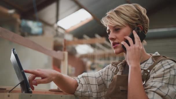 Učednice Tesařky Dílně Nábytku Pomocí Digitálního Tabletu Mluvení Mobilním Telefonu — Stock video