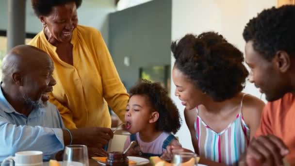 Familjen Äter Frukost Med Morföräldrar Och Barnbarn Äter Melon Hemma — Stockvideo