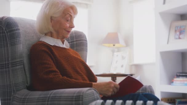 Senior Woman Sitting Armchair Portable Radiator Home Reading Book Keeping — Stock Video