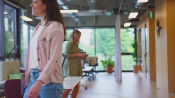 現代オフィスのブレイクアウトシーティングエリアに座って作業する前にオフィスを歩くノートパソコンを持つビジネスマン スローモーションで撮影 — ストック動画