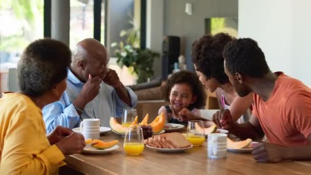 Familie Frühstückt Mit Großeltern Und Enkelin Und Zieht Lustige Gesichter — Stockvideo