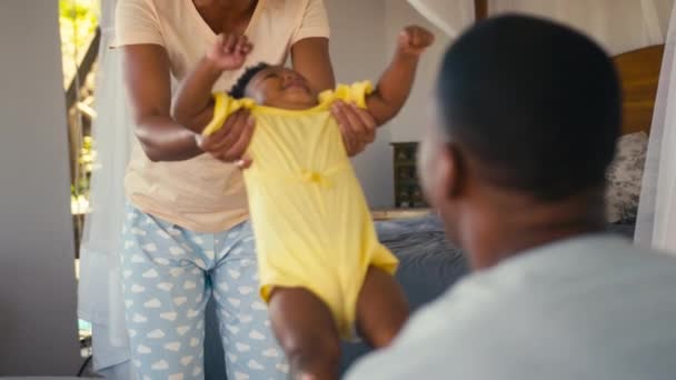 Família Usando Pijama Brincando Com Jovem Filha Balançando Para Cima — Vídeo de Stock