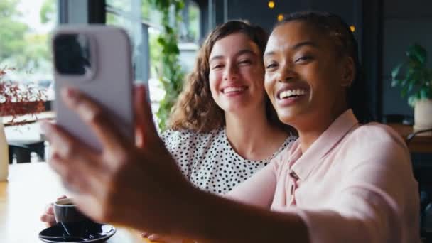 Dvě Mladé Přítelkyně Setkání Kavárně Pózování Pro Selfie Mobilním Telefonu — Stock video