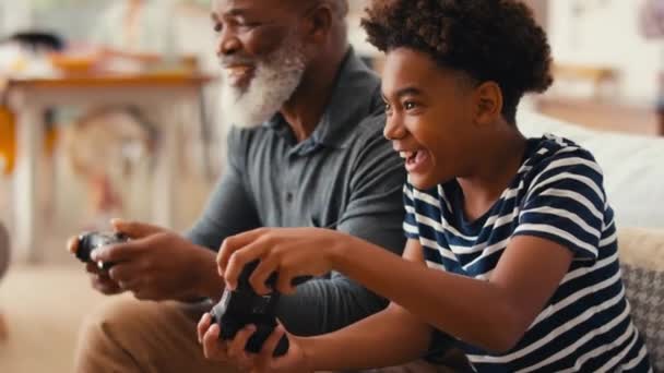 Avô Neto Sentados Sofá Casa Segurando Controladores Jogando Videogame Junto — Vídeo de Stock