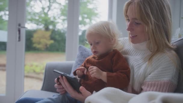 살아있는 에너지 위기의 스마트 미터와 소파에 아들과 어머니 슬로우 모션에서 — 비디오