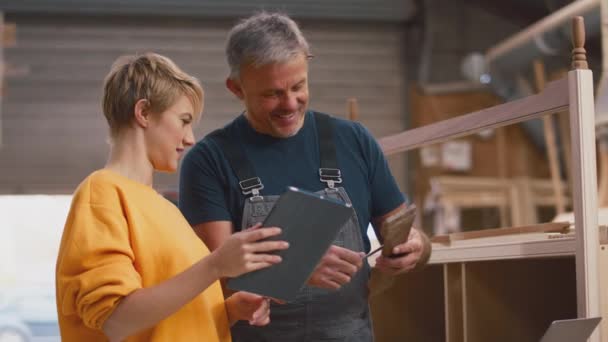 家具厂具有数字平板与女学徒共享木工操作技能的成熟男性木匠 慢镜头拍摄 — 图库视频影像